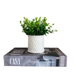 Livro decorativo 'Casa' e vaso branco de cerâmica trabalhado